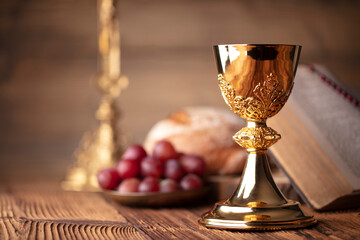 Catholic religion concept. Catholic symbols composition. The Cross, Holy Bible and golden chalice...