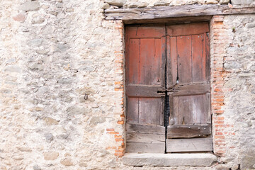 Fototapeta na wymiar Old wooden door. An old and dilapidated wooden door in an old house in Tuscany.