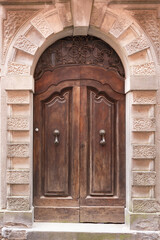 Beautiful front door. Carved door with metal forging. Entrance to one of the old houses in Barga.