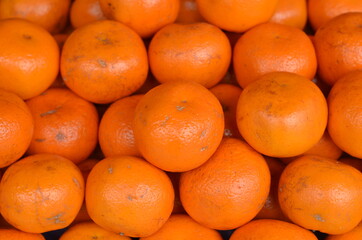 A collection of ripe sunkist fruits that are on display at the market.