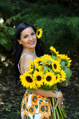 Mujer Joven Guatemalteca con un ramo de girasoles Chica joven usando un vestido con flores en un bosque.