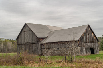 Fototapeta premium Historical Barn on the farm in early spring on an overcast day