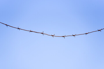 barbed wire against a blue sky background
