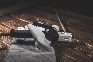 The holder of the welding electrode with an electrode, lie in a welding glove on a wooden...