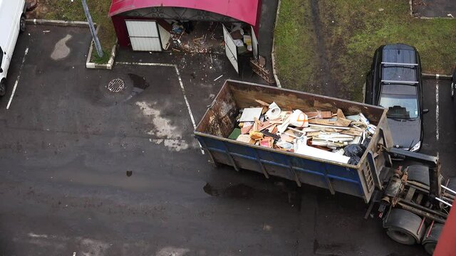 Cleaners load garbage into the car. 4K.