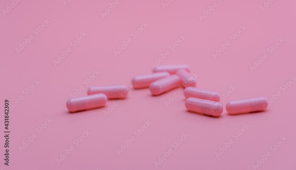 Wall mural pink capsules pill on pink background. vitamins and supplements. online pharmacy. pharmacy store ban