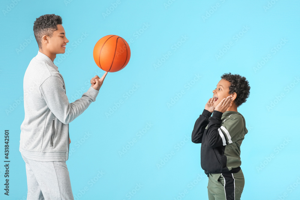 Wall mural African-American boys playing basketball on color background - Wall murals