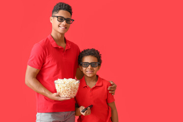 African-American boys watching movie on color background