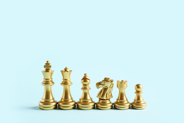 Golden chess figures on color background
