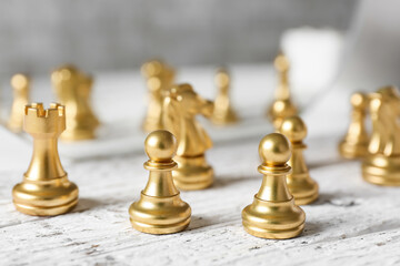 Chess figures on white wooden background
