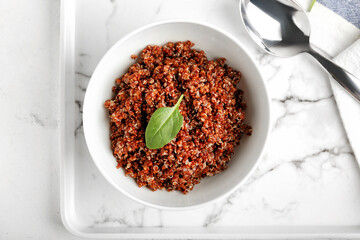 Bowl with tasty quinoa on light background