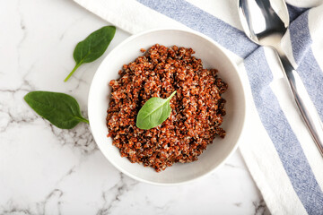 Bowl with tasty quinoa on light background