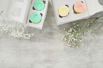 Composition with tasty cupcakes and flowers on light background