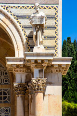 Naklejka premium Jerusalem, Israel - 27 april 2021: facade of Church of All Nations, also known as Basilica of Agony is supported by row of Corinthian columns with statues of 4 Evangelists. The final statue is of John
