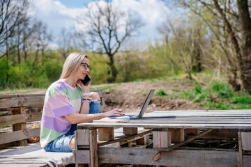 Woman with glasses working outdoors on a beautiful sunny day. Traveling with the computer.