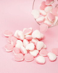 Fototapeta na wymiar Heart-shaped candy with two different colored sides sprinkled with powdered sugar. Chewy candy is loved by all ages. Suitable as a snack in spare time or a snack when hanging out with friends. 