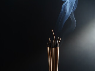 Burning incense white smoke black background used as a worship background image a sacred object of Buddhist beliefs focuses on the smoke.