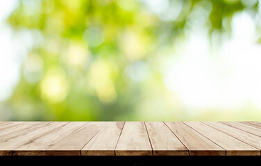 blurred background of green park in summer, Wood table top on shiny bokeh green background. For...