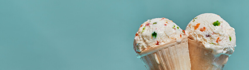 Ice cream with fruit sweets in waffle cones with free space for text banner
