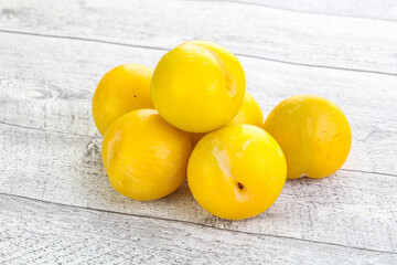 Ripe sweet yellow plum heap over background