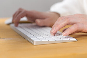 Woman office worker typing on white keyboard