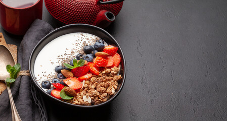 Healthy breakfast with bowl of granola, yogurt and fresh berries