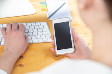 woman hands close up working on white computer keyboard and smartphone, work from home concept. work online, shopping