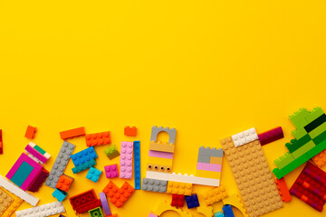 Kids toy constructor details scattered on yellow background