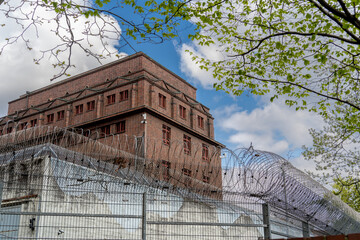 Hauptgeb&auml;ude mit Mauer und Stacheldrahtzaun der Untersuchungshaftanstalt Hamburg, Deutschland