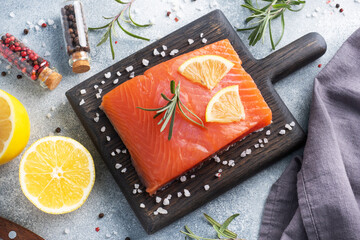Salmon fillet, red salted fish on a wooden chopping Board. Lemon, rosemary spices.