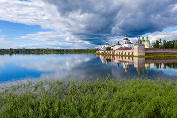Fototapeta premium View of Kirillo-Belozersky Monastery and lake Siverskoye on sunny summer day with dramatic clouds. Kirillov, Vologda Oblast, Russia.