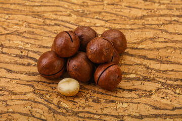 Brown macadamia nut heap over background