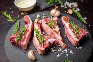 Fresh raw  beef and ingredients steak on black stone board over black wooden table