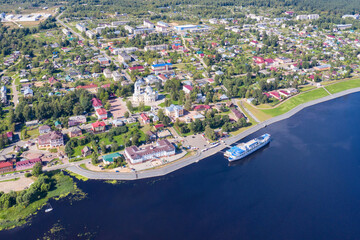 Obraz premium Aerial view of Myshkin town and cruise ship on Volga river on sunny summer day. Yaroslavl Oblast, Russia.