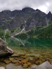 Travel to the Tatra Mountains, Mountain Lake - Morskie Oko, or Eye of the Sea. Summer. Mountain peaks in the clouds. Poland