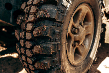 Wheel of offroad car in a muddy roadn forest