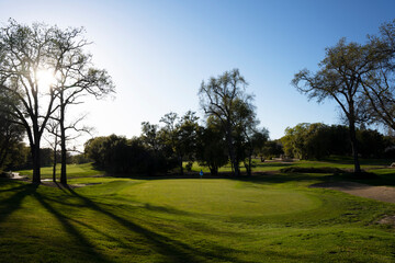 Obraz premium Putting green on beautiful golf course at sunset.
