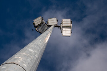 Powerful LED light on a aluminum metal pole , cloudy sky background. Concept sport event, game. Modern light source