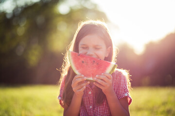  Fruit day. Portrait of little girl holding piece of watermelon. - 431856584