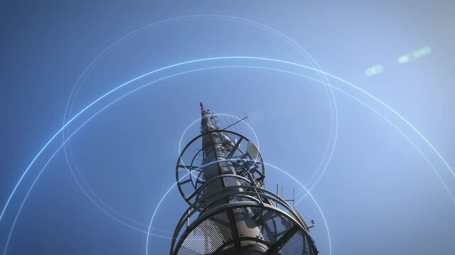 Low angle view of 5G communication mast against blue sky sends signal waves into the world
