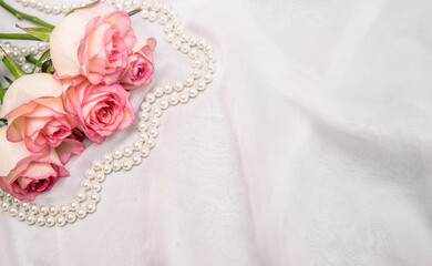 Obraz na płótnie Canvas The branch of pink rose on white fabric background 