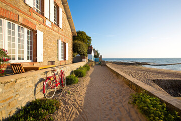 Vue sur mer sur l'île de Noirmoutier en Vendée, vieux vélo rouge en bord de plage.
