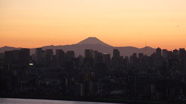 TOKYO, JAPAN : Aerial high angle sunrise or sunset view of CITYSCAPE of TOKYO and MOUNT FUJI. View of buildings at central downtown area. Japanese nature and city life concept. Real time shot.