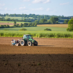 Obraz premium Tracteur en campagne labourant la terre au printemps en France.