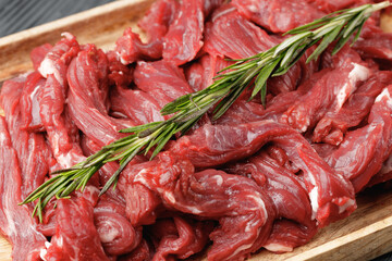 Raw sliced beef meat on wooden board