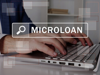  MICROLOAN text in search bar. Loan officer looking for something at laptop. MICROLOAN concept.