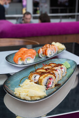 Sushi rolls with ginger and wasabi on the table in a restaurant.