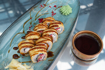 Sushi rolls with soy sauce on the table.