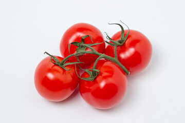 Tomatoes on a vine on a white background. Fresh and healthy vegetable. Ripe and juicy tomato