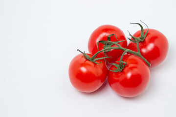 Tomatoes on a vine on a white background. Fresh and healthy vegetable. Ripe and juicy tomato